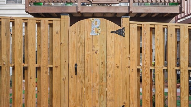 Una puerta de madera con un cerradero y la letra 'B' en la puerta.