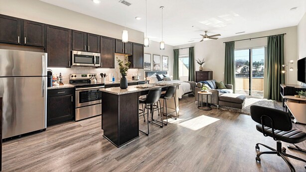 A modern kitchen with dark cabinets, stainless steel appliances, and pendant lighting. - The Golden Retreat- Mountain Views + Private Patio (Golden)