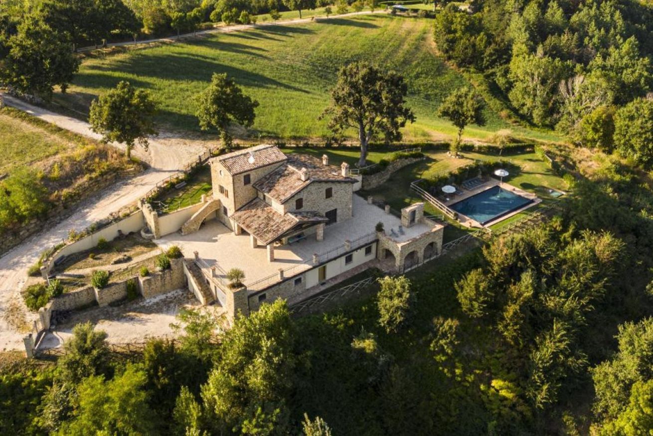 Une villa avec piscine, entourée d’une végétation luxuriante et de champs en terrasses.