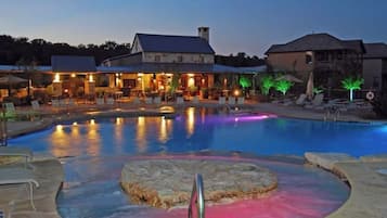 Una piscina con hidromasaje, sillas de descanso y un edificio con techo.