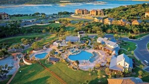 Eine Luftaufnahme einer Wohngegend mit mehreren Häusern, einem großen Schwimmbad und einem Golfplatz.