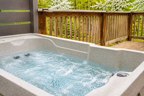 A hot tub with a wooden deck and a wooden fence in the background. - Creekside Cabin W/ Pool Access & Hot Tub Near Thunder Ridge • Sleeps 4 (Blue Eye)