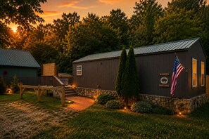 Un chalet en bois avec des fondations en pierre, une terrasse en bois et un drapeau.