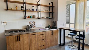 Una cocina moderna con armarios de madera, una estufa a gas y un ventanal con vistas.