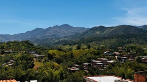 Un paisaje montañoso con un pueblo en primer plano.