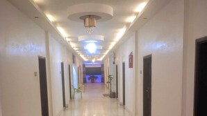 A long, well-lit hallway with doors on both sides, leading to a brightly lit area at the end. - Gazi Residential Hotel Chandpur (Chandpur)
