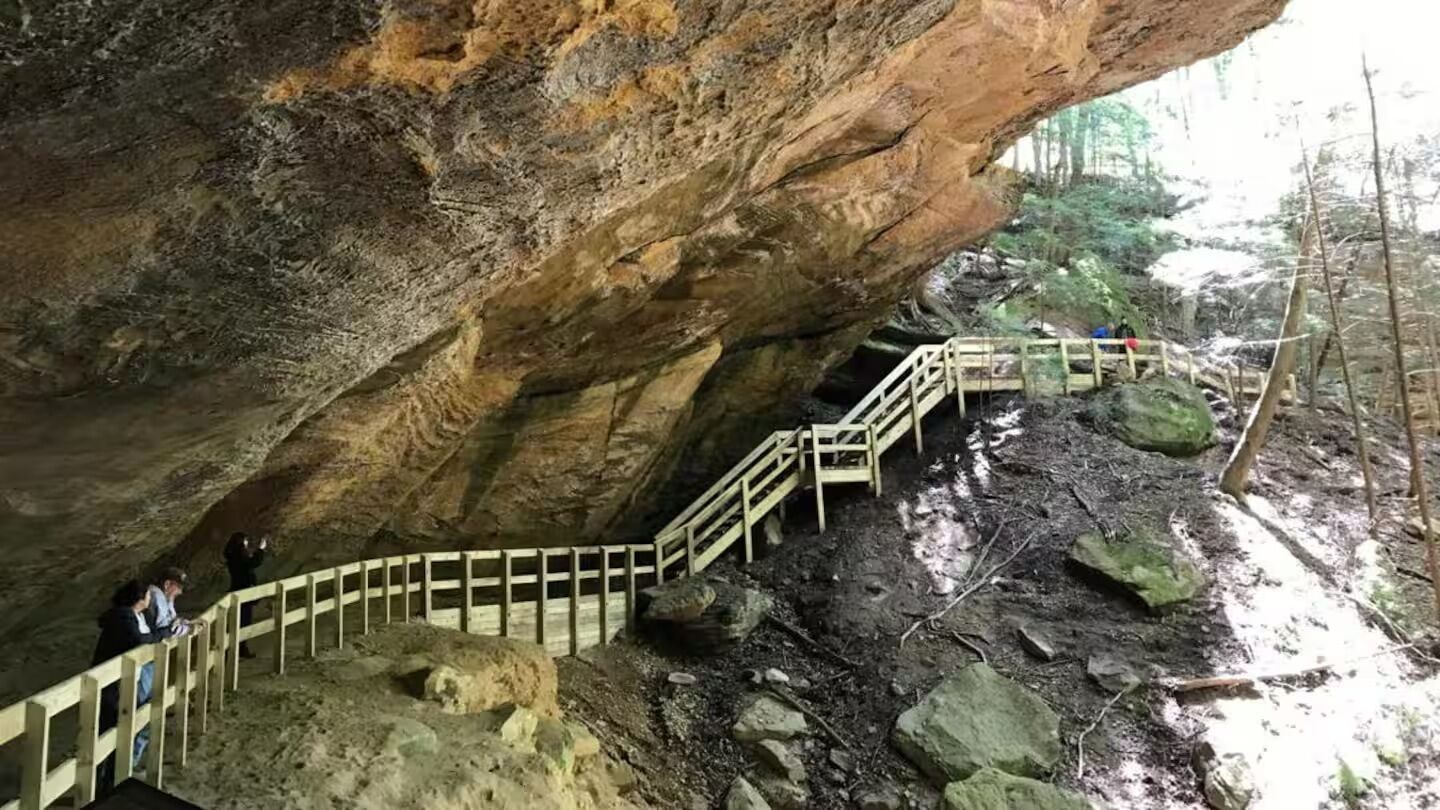 A cave with wooden staircases and rocky terrain.