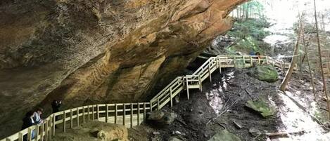 A cave with wooden staircases and rocky terrain.