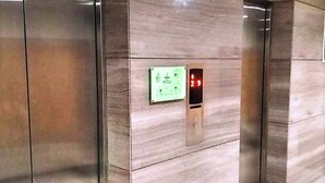 Un ascenseur moderne doté d’un écran numérique et d’un panneau de commande.
