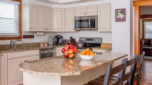 A kitchen with a central island, a microwave, and a coffee maker. - The Osborne House 1930 near Gore Mountain with ARCADE! Air conditioned! (North Creek)