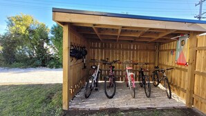 A wooden shed with a roof, containing bicycles and helmets. - Central Blenheim Character House - Kitchen, Laundry, BBQ, Bikes (Blenheim)