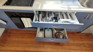 A kitchen with a built-in stove, a sink, and a drawer organizer with utensils. - Central Blenheim Character House - Kitchen, Laundry, BBQ, Bikes (Blenheim)