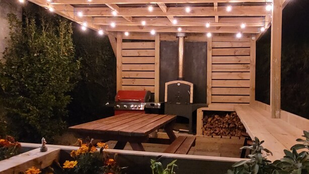 An outdoor patio with a wooden table, a barbecue grill, and a fire pit. - Central Blenheim Character House - Kitchen, Laundry, BBQ, Bikes (Blenheim)