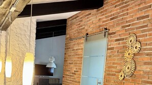 A modern office space with a brick wall, a wooden desk, and a glass partition.