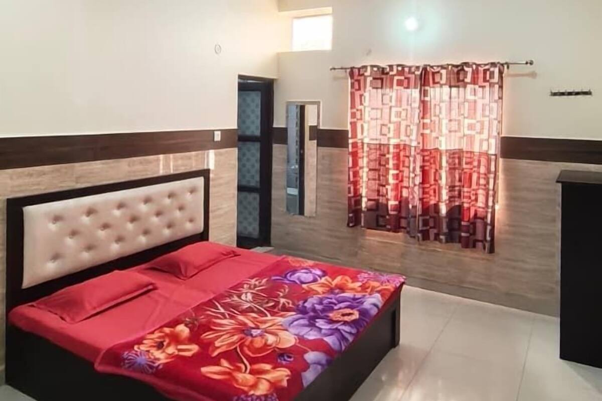 A bedroom with a bed, a ceiling fan, and a window with curtains.