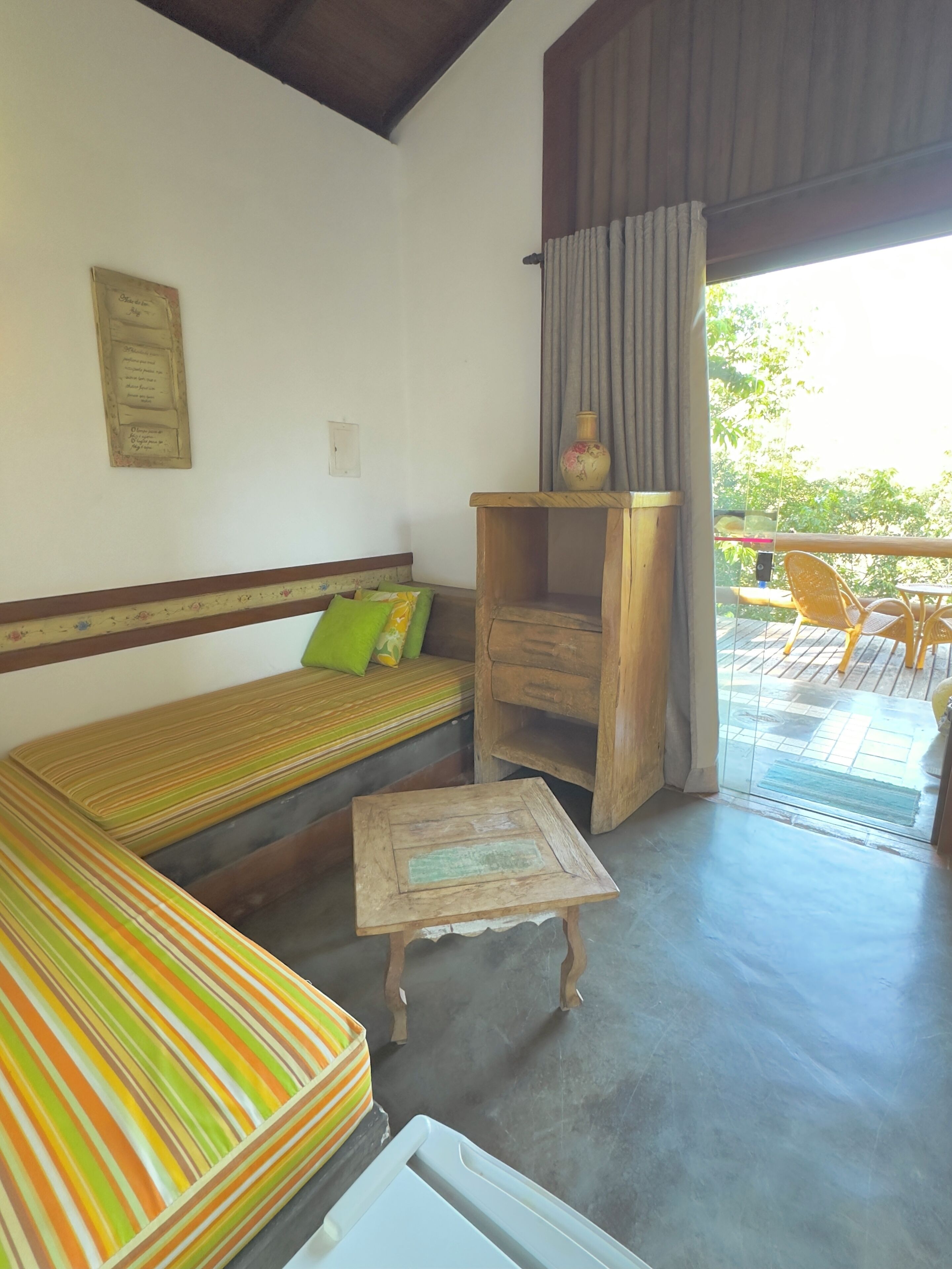 A room with a striped sofa, a small wooden table, and a wooden cabinet.