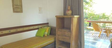 A room with a striped sofa, a small wooden table, and a wooden cabinet.