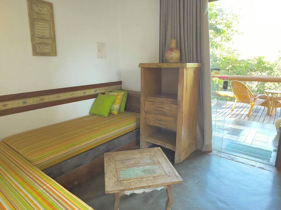 A room with a striped sofa, a small wooden table, and a wooden cabinet.