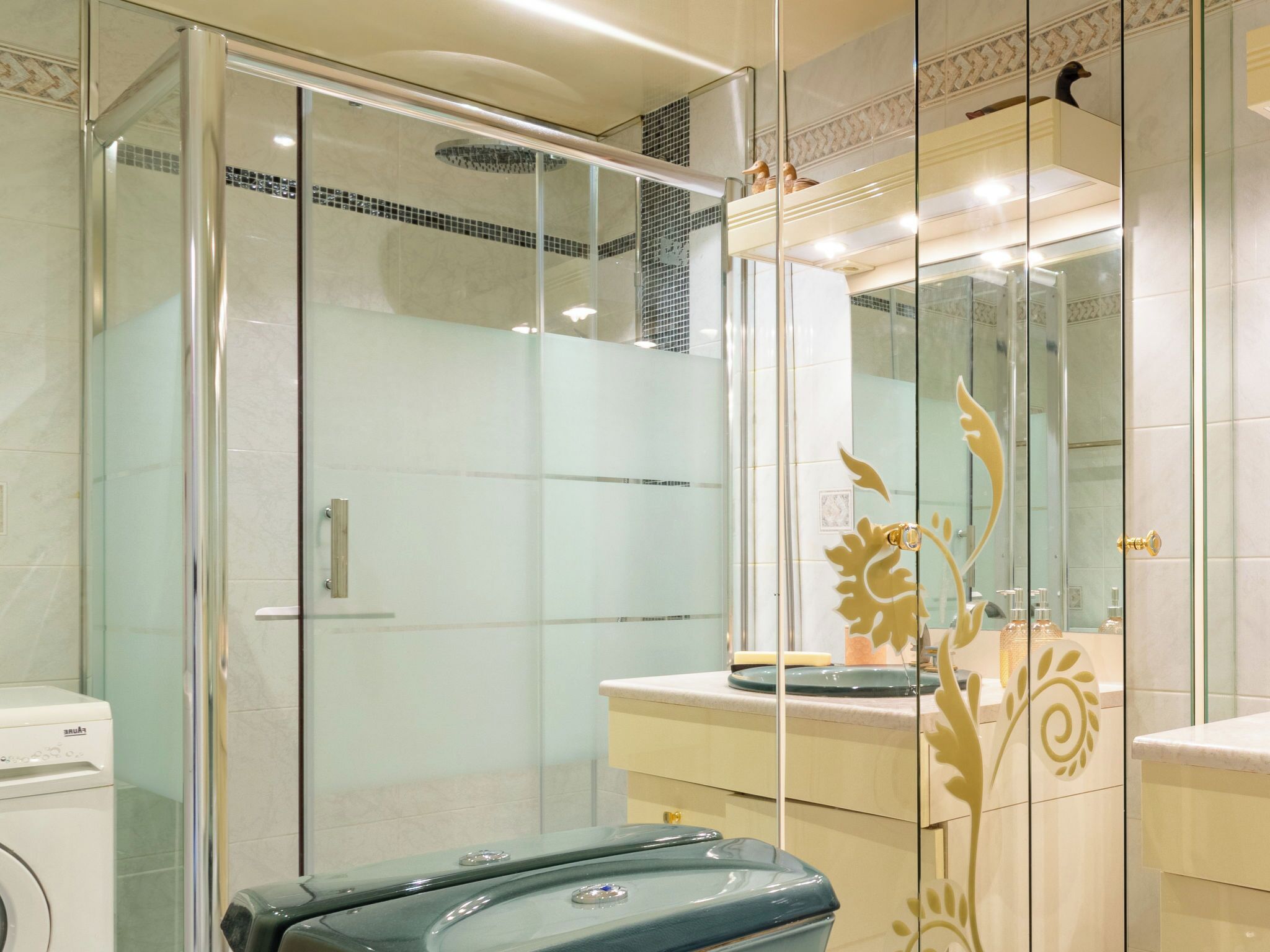 A modern bathroom with a glass shower enclosure, a built-in toilet, and a vanity with a mirror.