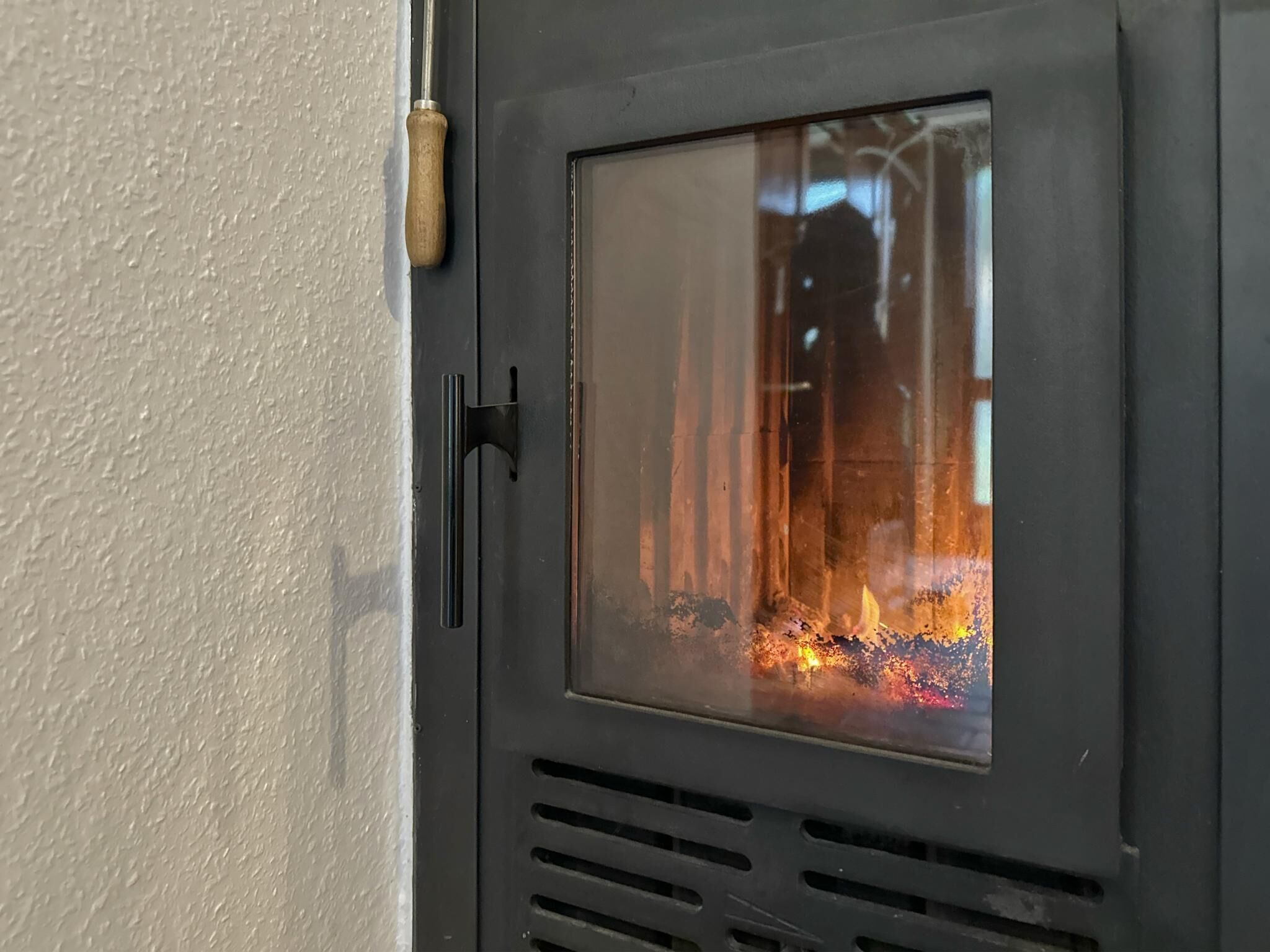 A metal door with a glass window, a handle, and a vent.