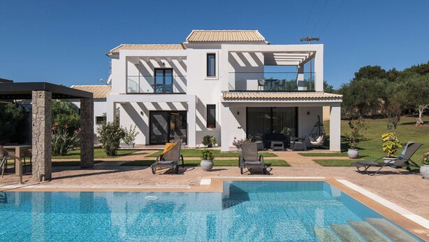 Una moderna casa a due piani con piscina, area salotto esterna e giardino.