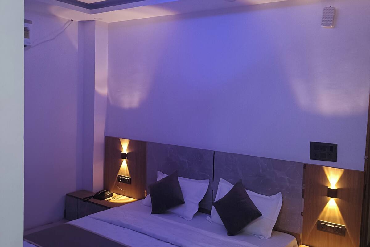 A modern bedroom with a bed, bedside lamps, a ceiling fan, and a nightstand.