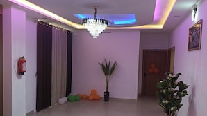 Una habitación amplia con ventilador de techo, candelabro y una planta en maceta.