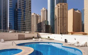 A swimming pool with lounge chairs, surrounded by high-rise buildings. - Skyline / Balcony / Waterfront & Marina Walk (Dubai)
