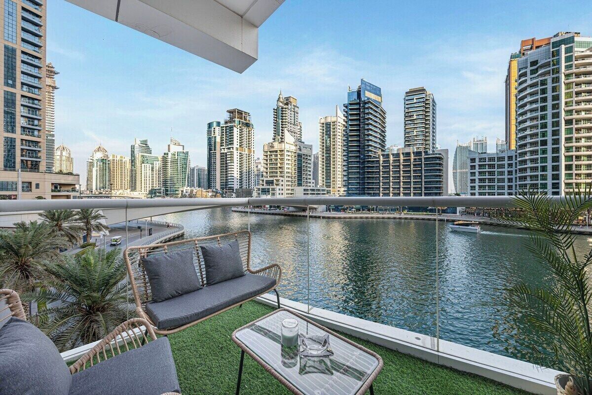 A balcony with a view of a city skyline and a body of water.