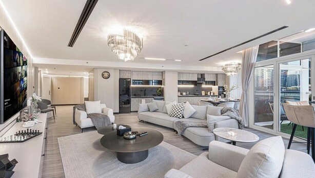 Una sala de estar moderna con sofá, mesa de centro y televisor.