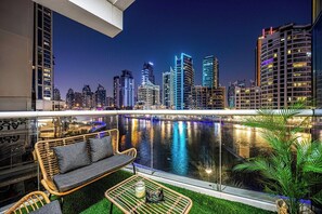 A balcony with a view of a city skyline at dusk, featuring modern buildings and a body of water. - Skyline / Balcony / Waterfront & Marina Walk (Dubai)