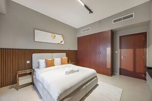 A modern bedroom with a large bed, wooden headboard, and a wall-mounted artwork. - Palm Views / Pool Table / Gym / Pool / opp Beach (Dubai)