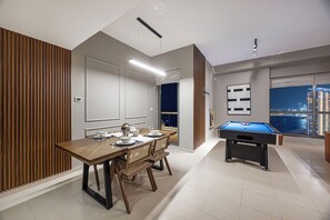 A modern dining area with a pool table, wooden paneling, and a city view. - NYE Atlantis Fireworks Show| Palm Views|Pool Table (Dubai)