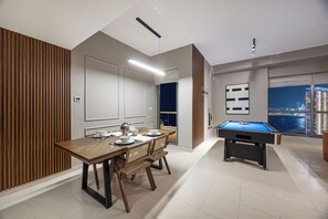A modern dining area with a pool table and a city view. - Palm Views / Pool Table / Gym / Pool / opp Beach (Dubai)