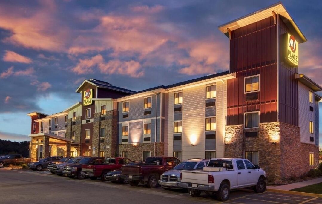 Arrive at a warmly lit hotel exterior at sunset.