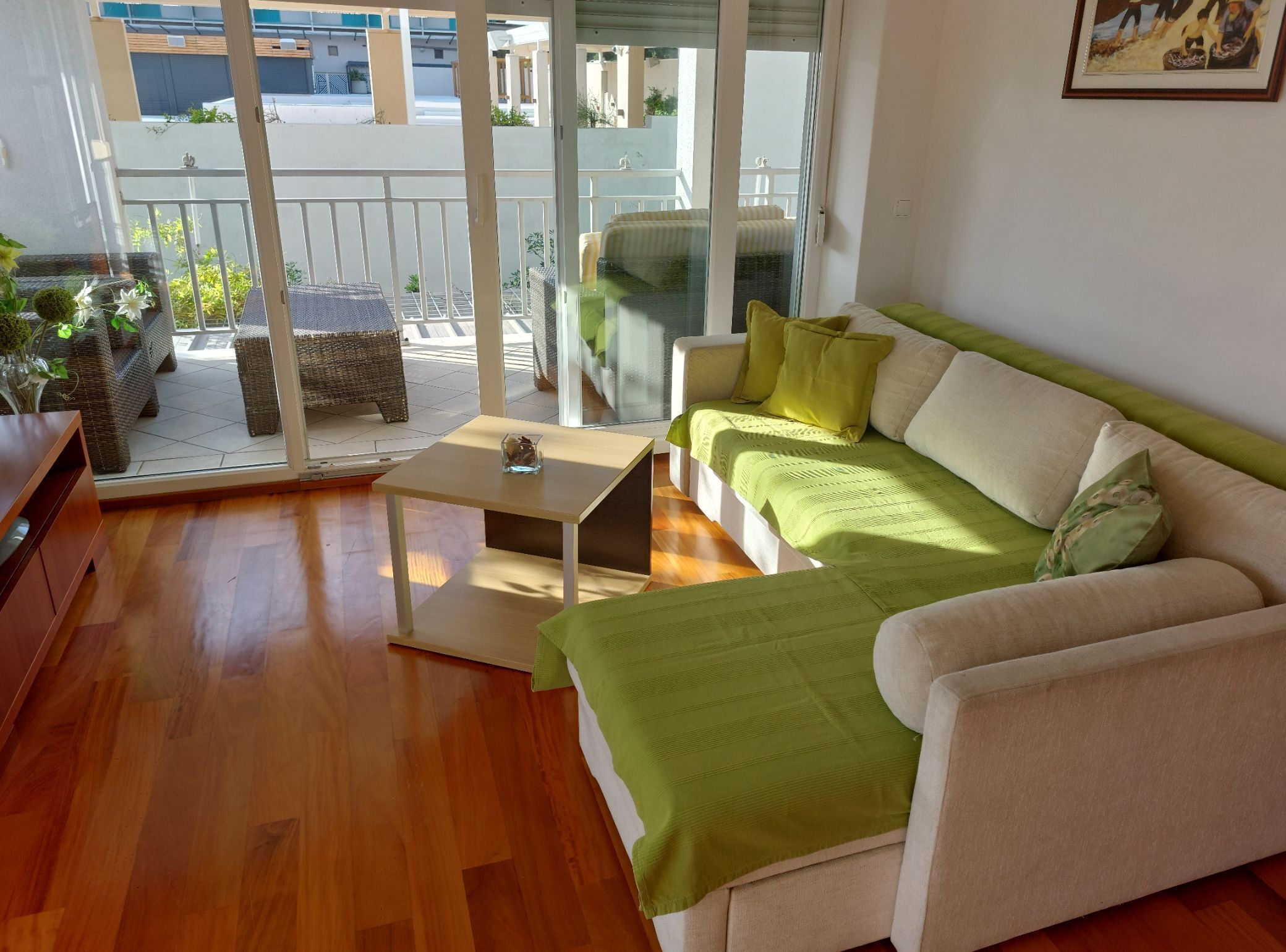 Una sala de estar moderna con un sofá, una mesita y vistas al balcón exterior.
