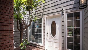 A house with a white front door, a brick wall, and a small tree in front. - Endless Family Entertainment, Fire Pit, 2 Kings! (Wichita)
