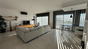 A modern living room with a sofa, TV, and dining area. - Beautiful Villa Martin AV-88 (Roses)