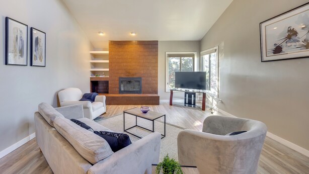A modern living room with a fireplace, a TV, and a comfortable seating area. - Pet-Friendly Condo w/ Mountain View in Monument! (Monument)