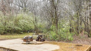 A concrete outdoor area with a barbecue grill and a fire pit.