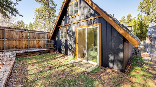 Una casa moderna con techo inclinado, ventanas amplias y una terraza de madera.