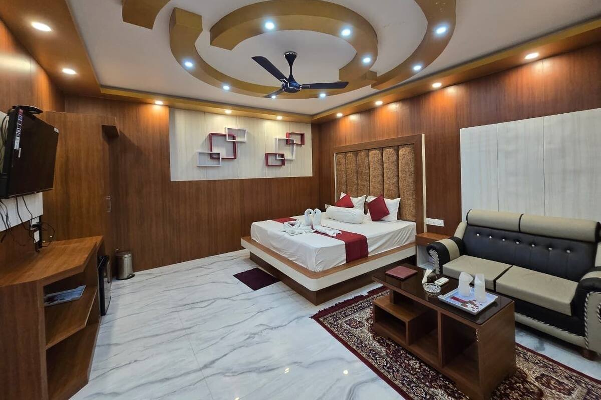 Una habitación de hotel moderna con cama, sofá y televisión.