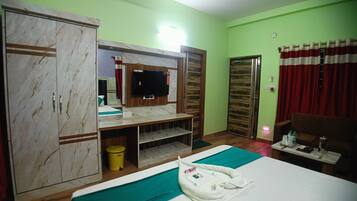 A hotel room with a bed, a wardrobe, a TV, a desk, and a bathroom.