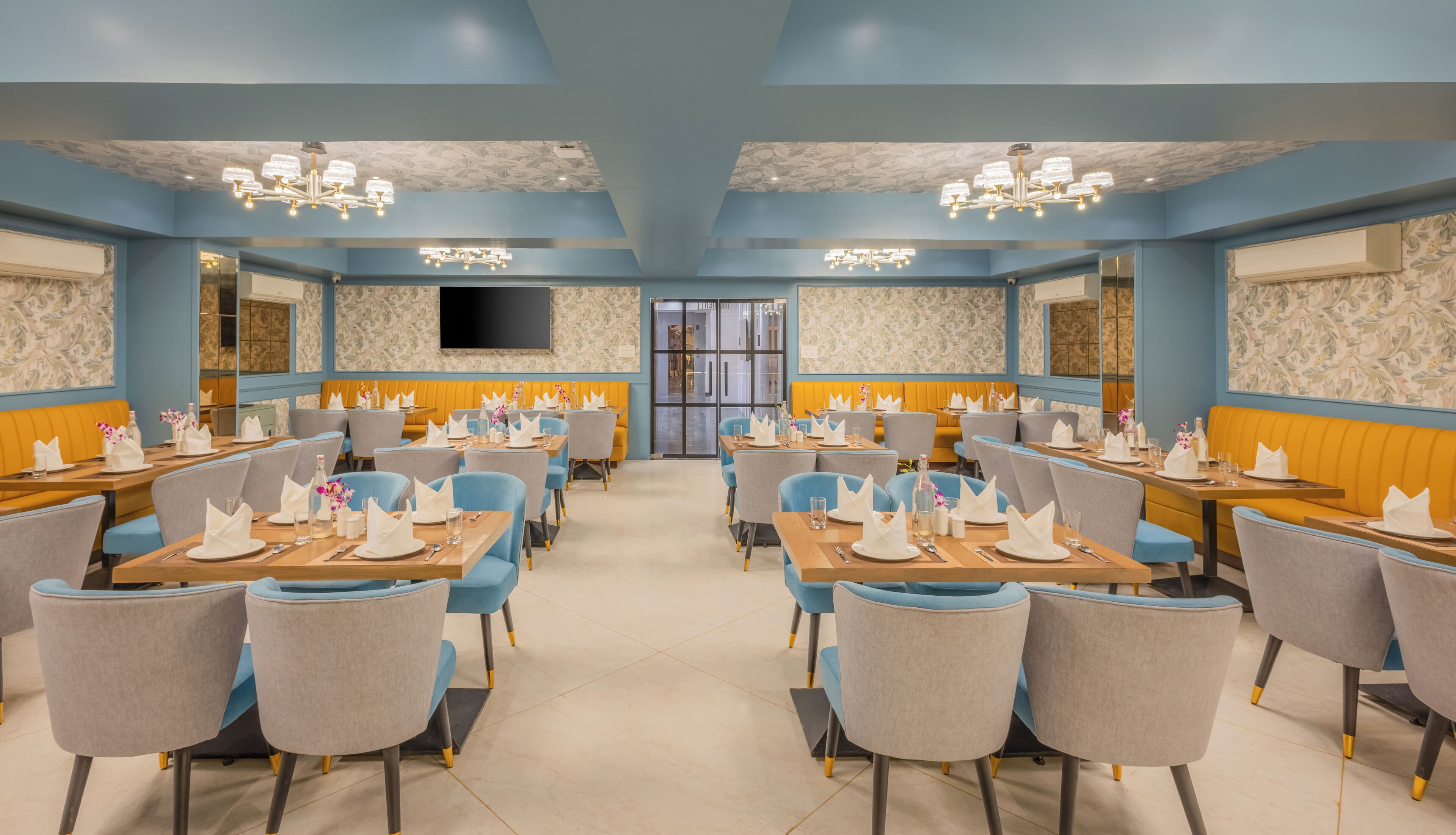 Un restaurante con paredes azules, mesas de madera y sillas grises.