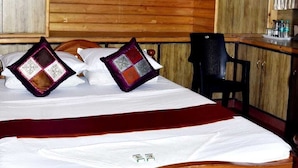 A wooden-paneled bedroom with a bed, a desk, and a chair. - SAS SERVICE APPARTMENT (Bengaluru)