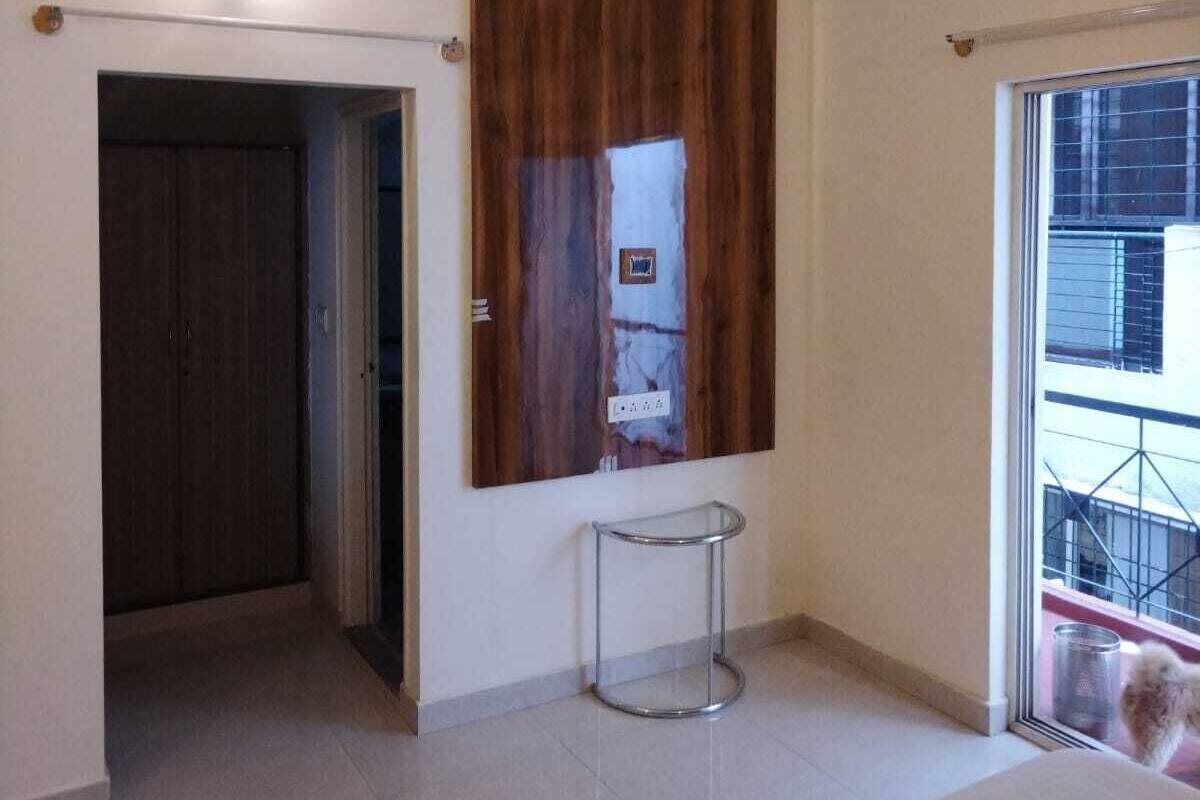 A modern interior with a wooden accent wall, a glass table, and a view of the outside.