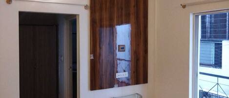 Un intérieur moderne avec un mur d’accent en bois, une table en verre et une vue sur l’extérieur.