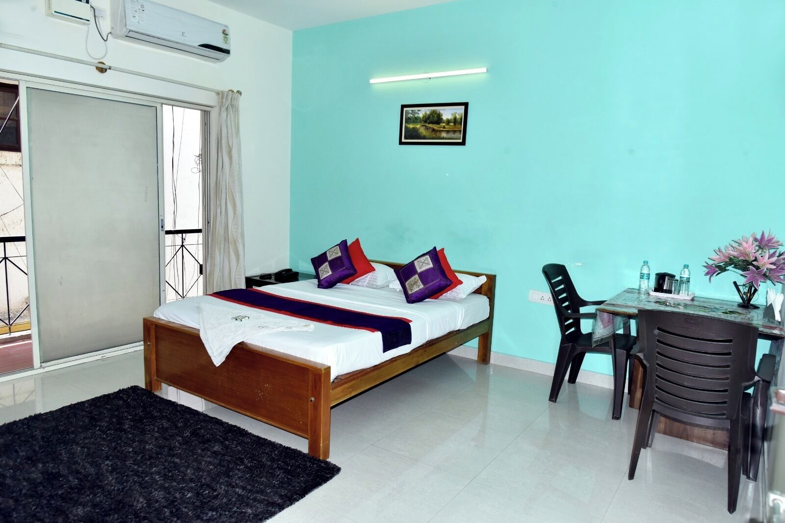 A bedroom with a bed, a desk, and a chair.