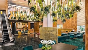 A lobby with a marble floor, a reception desk, seating areas, and an escalator. - Modern Queen Size in Downtown Area (Los Angeles)