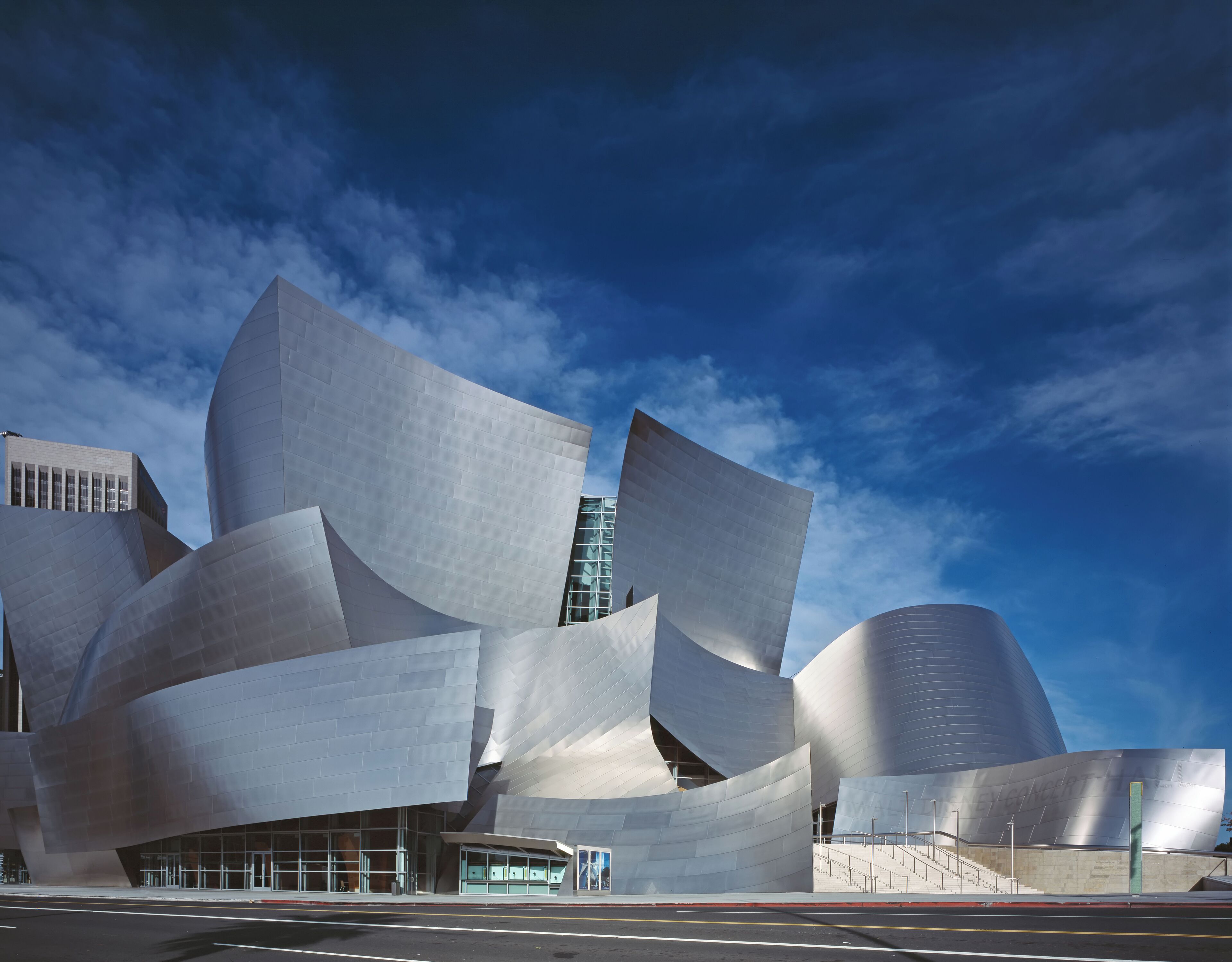 A modern architectural building with a unique, curved design and a prominent entrance.